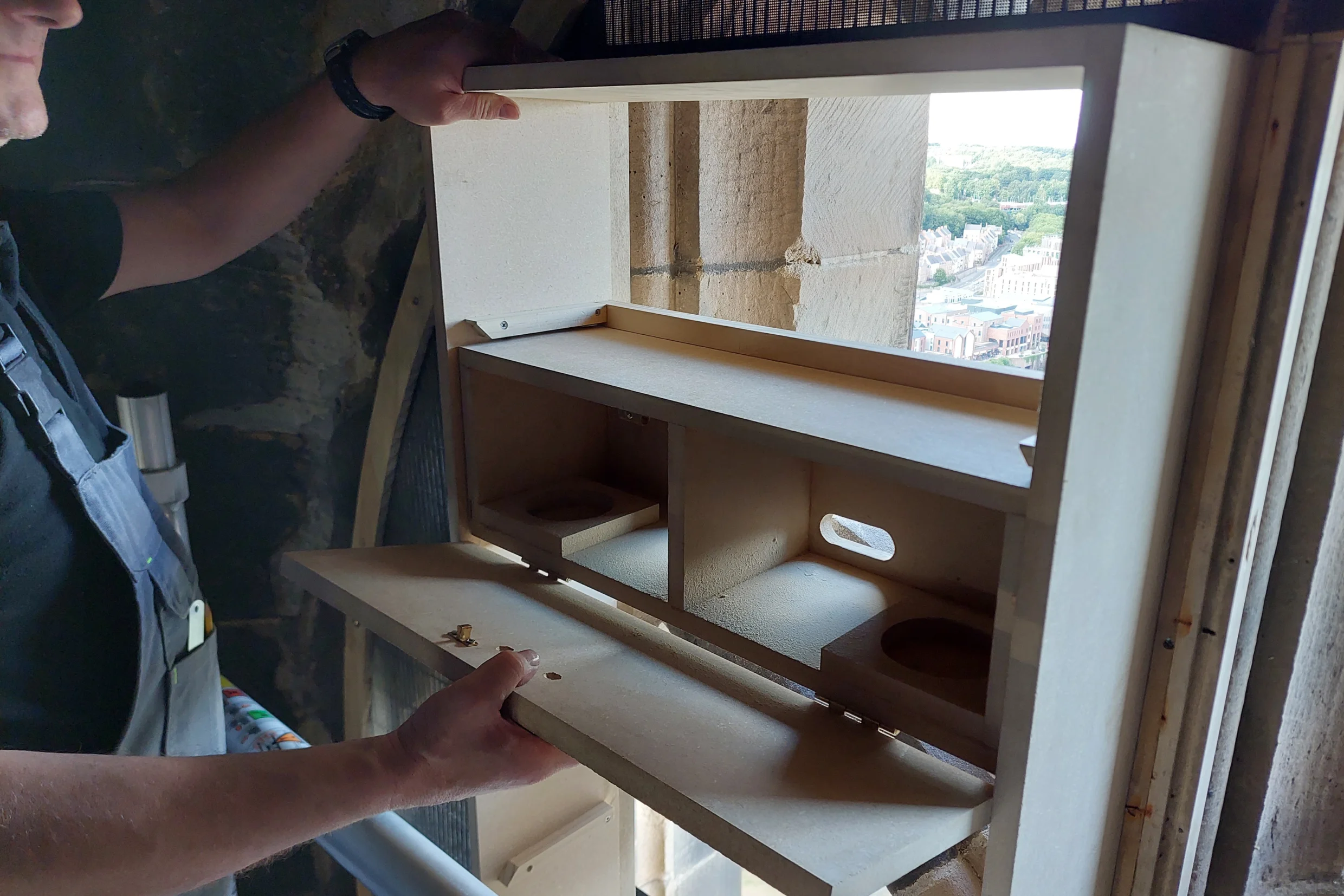 Builder adding swift box to tower window